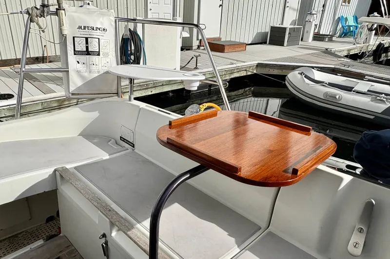 Slide: The Image of Cockpit of 1985 Beneteau First 345 sailboat with wooden table and dock view. - 3