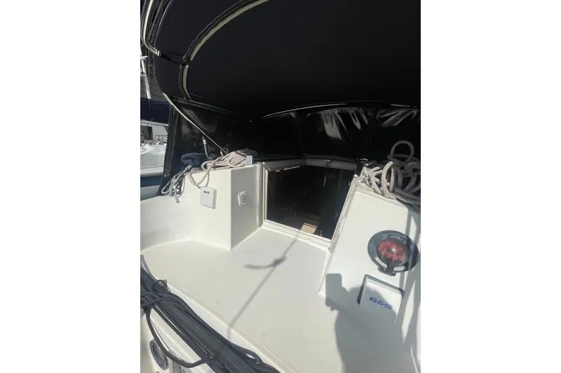 Slide: The Image of 1985 Beneteau First 345 sailboat cockpit with ropes and equipment under a black canopy. - 8