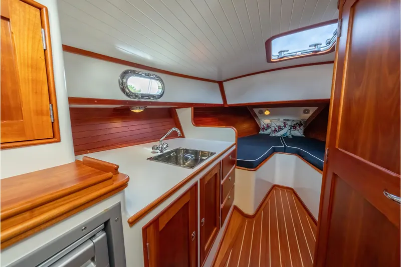 Slide: The Image of 2020 CH Marine Shelter Island Nomad interior with wooden cabinetry and compact kitchenette. - 1