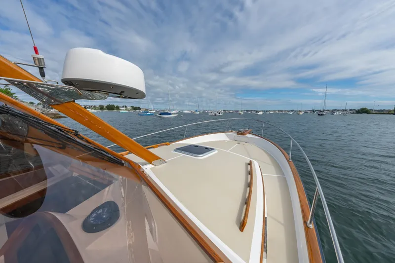 Slide: The Image of 2020 CH Marine Shelter Island Nomad boat on calm waters under a cloudy sky. - 14