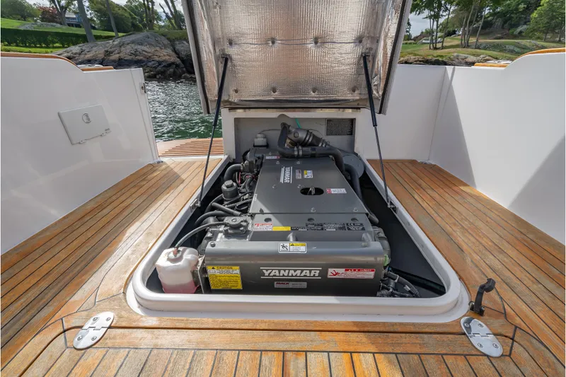 Slide: The Image of 2020 CH Marine Shelter Island Nomad engine compartment with Yanmar engine, open hatch, wooden deck. - 17