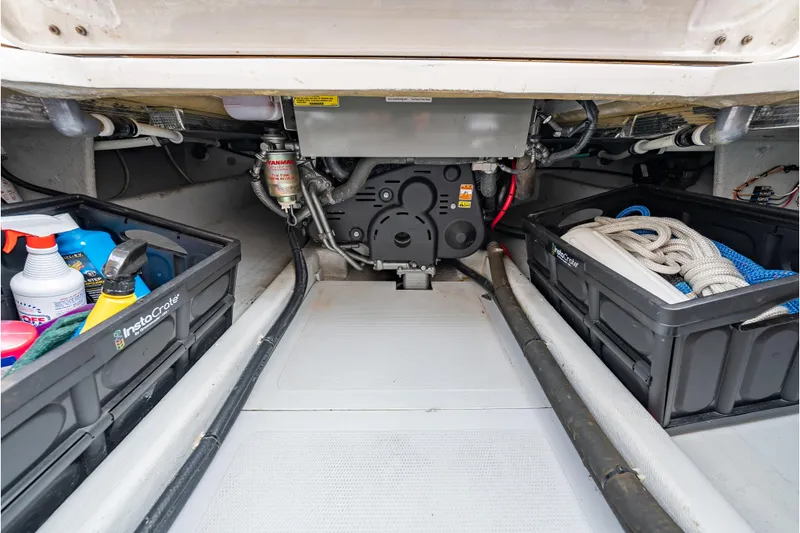 Slide: The Image of 2020 CH Marine Shelter Island Nomad engine compartment with storage crates and maintenance supplies. - 18
