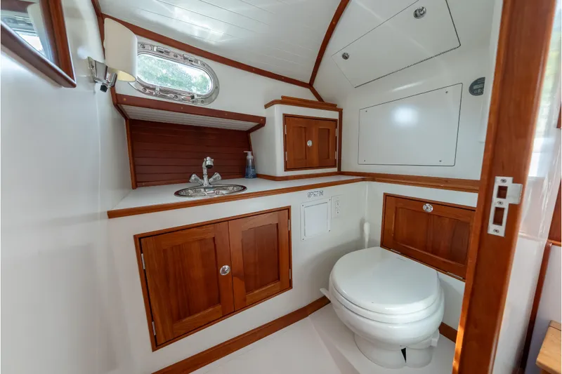 Slide: The Image of 2020 CH Marine Shelter Island Nomad boat bathroom with wooden cabinets and modern fixtures. - 2