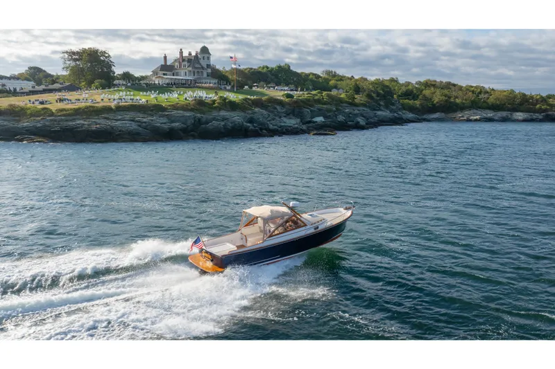 Slide: The Image of 2020 CH Marine Shelter Island Nomad cruising near a scenic coastal estate. - 21