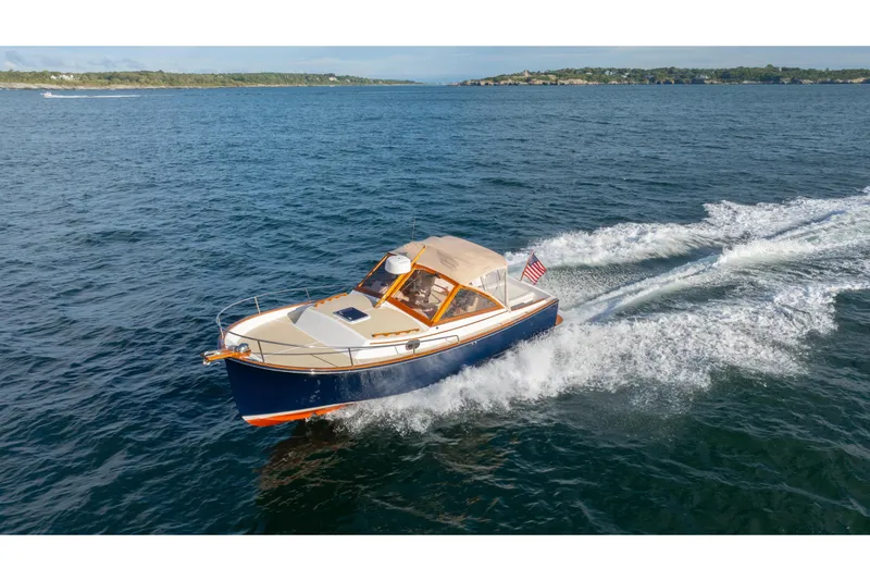 Slide: The Image of 2020 CH Marine Shelter Island Nomad cruising on open water, displaying sleek design and American flag. - 24