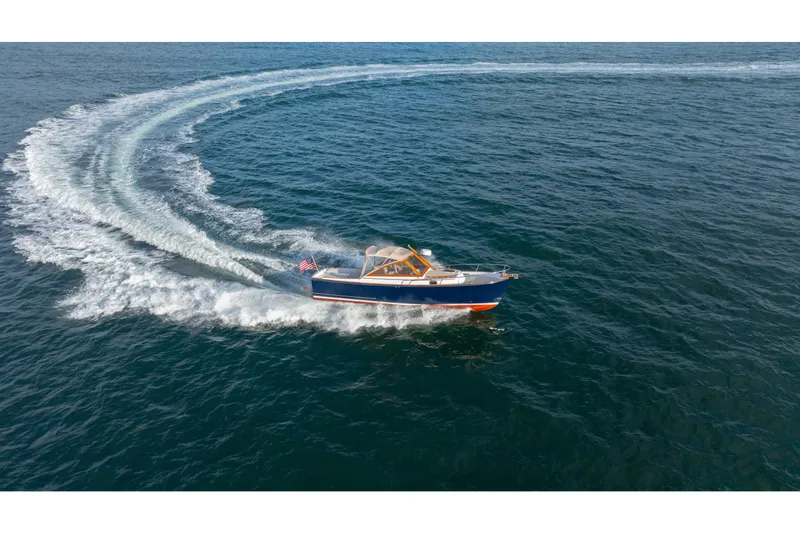 Slide: The Image of 2020 CH Marine Shelter Island Nomad cruising on open water, creating a circular wake. - 25