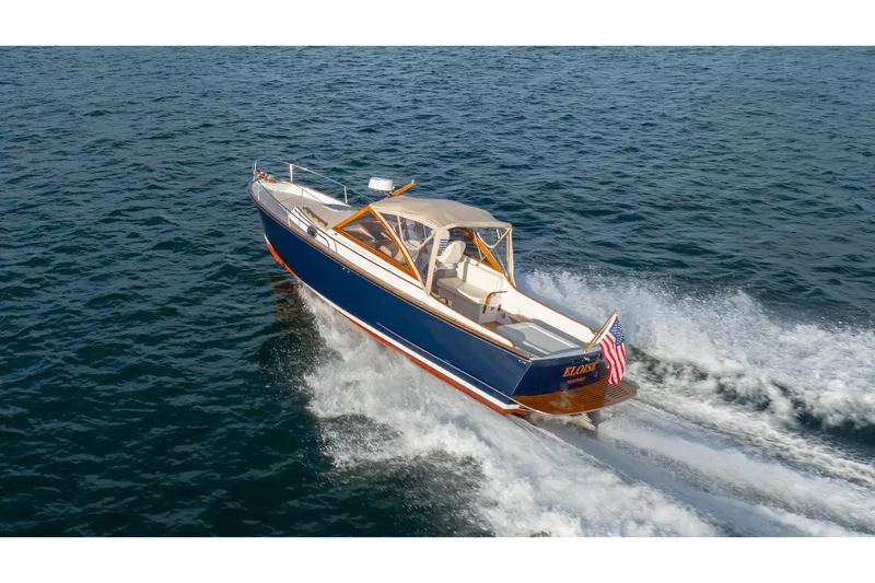 Slide: The Image of 2020 CH Marine Shelter Island Nomad cruising on open water, displaying sleek design and American flag. - 27