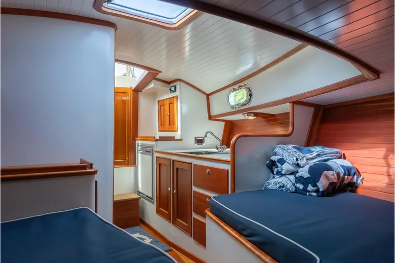Slide: The Image of 2020 CH Marine Shelter Island Nomad interior with wood cabinetry and cozy sleeping area. - 4