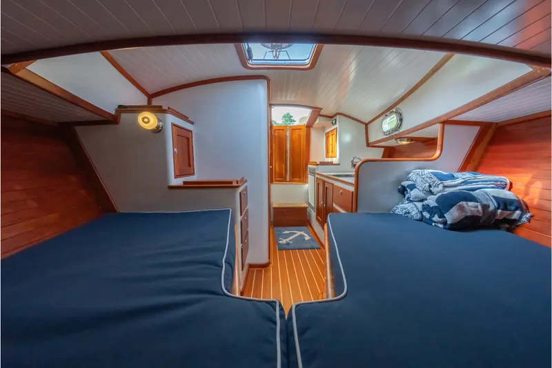Slide: The Image of Cozy interior of 2020 CH Marine Shelter Island Nomad with twin beds and wooden accents. - 5