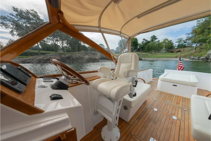 Slide: The Image of 2020 CH Marine Shelter Island Nomad boat interior with helm, seating, and scenic water view. - 6