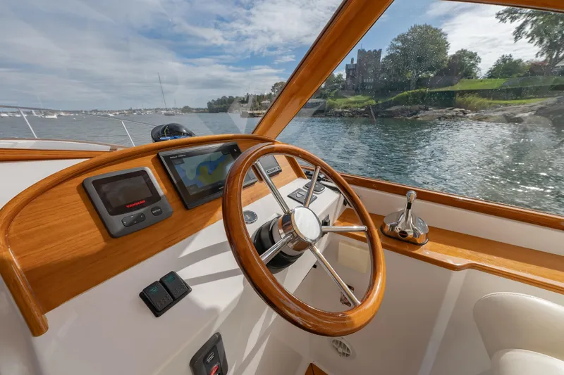 Slide: The Image of 2020 CH Marine Shelter Island Nomad boat interior with steering wheel and navigation system. - 7