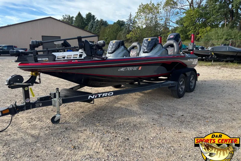 Slide: The Image of 2017 Nitro Z18 fishing boat on trailer, parked outdoors near trees and a building. - 4