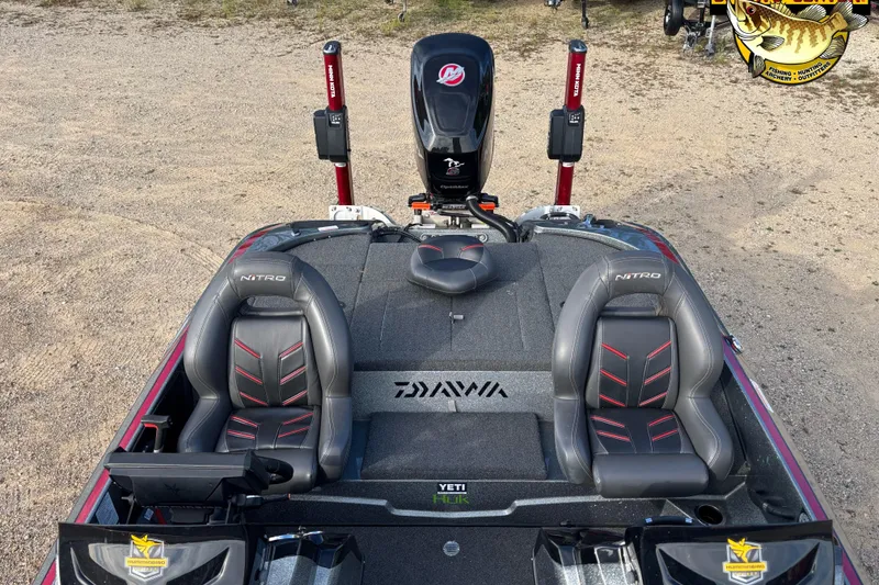 Slide: The Image of 2017 Nitro Z18 boat interior with dual seats and motor, parked on sandy ground. - 7