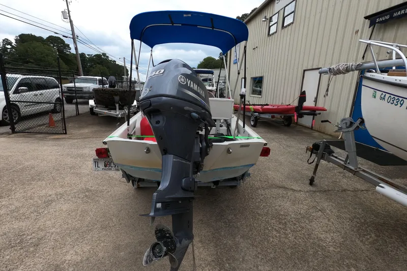 Slide: The Image of 1992 Boston Whaler 13 GLS boat with Yamaha outboard motor, parked in a marina. - 11