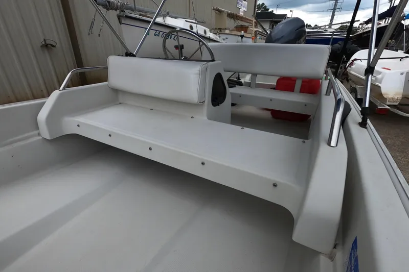 Slide: The Image of 1992 Boston Whaler 13 GLS boat interior with white seating and metal railings. - 5