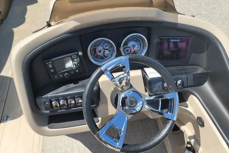 Slide: The Image of 2020 Avalon Catalina Elite boat dashboard with chrome steering wheel and navigation controls. - 11