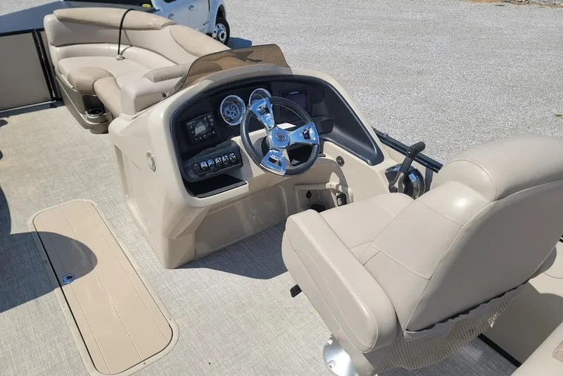 Slide: The Image of 2020 Avalon Catalina Elite 23' boat interior with beige seating and modern dashboard. - 14