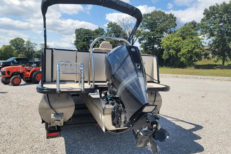 Slide: The Image of 2020 Avalon Catalina Elite 23' pontoon boat with outboard motor, parked outdoors. - 21