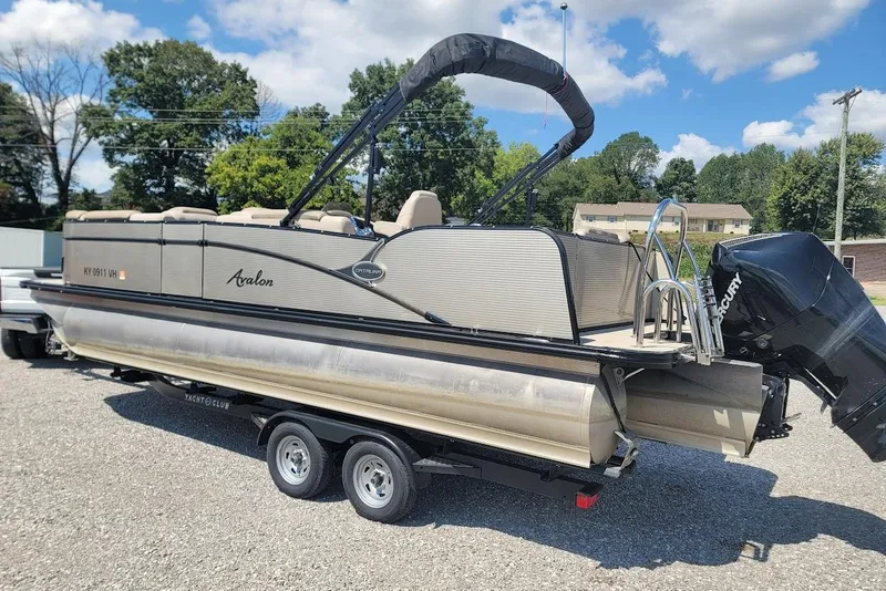 Slide: The Image of 2020 Avalon Catalina Elite 23' pontoon boat on trailer, outdoors under blue sky. - 6