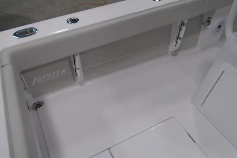 Slide: The Image of Interior view of a 2026 Jupiter 26 boat, featuring sleek white design and branding. - 22