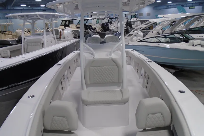 Slide: The Image of 2026 Jupiter 26 boat interior with white seating, displayed in a showroom. - 26