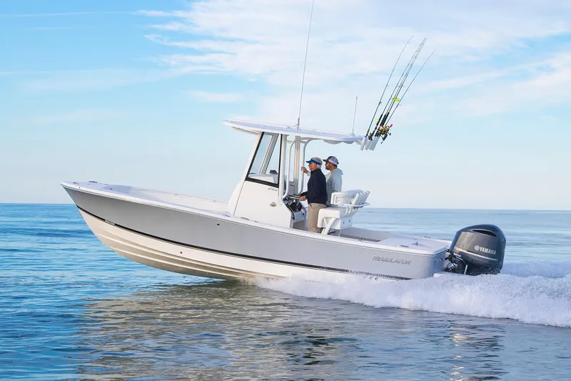 The Image of 2026 Regulator 24XO boat on trailer, parked outdoors under cloudy sky. - 0