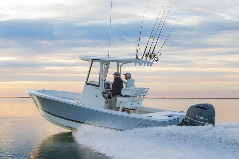 Slide: The Image of 2026 Regulator 24XO boat on trailer, parked outdoors, showcasing sleek design and modern features. - 2