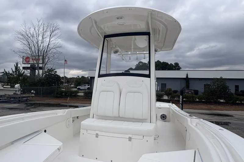 Slide: The Image of 2026 Regulator 24XO boat interior with seating and outboard motor, under cloudy sky. - 9