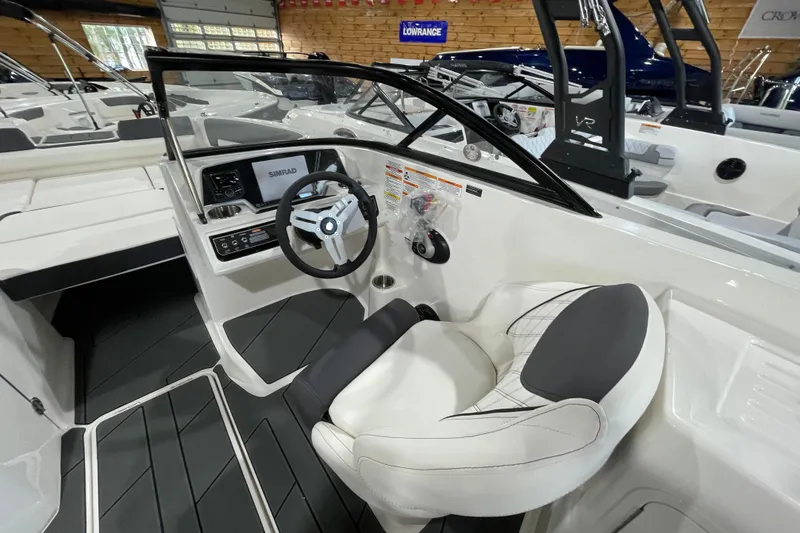 Slide: The Image of 2026 Bayliner D22I boat interior with steering wheel and dashboard in showroom. - 10