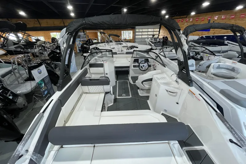 Slide: The Image of 2026 Bayliner D22I boat interior with modern seating and steering, displayed in a showroom. - 16