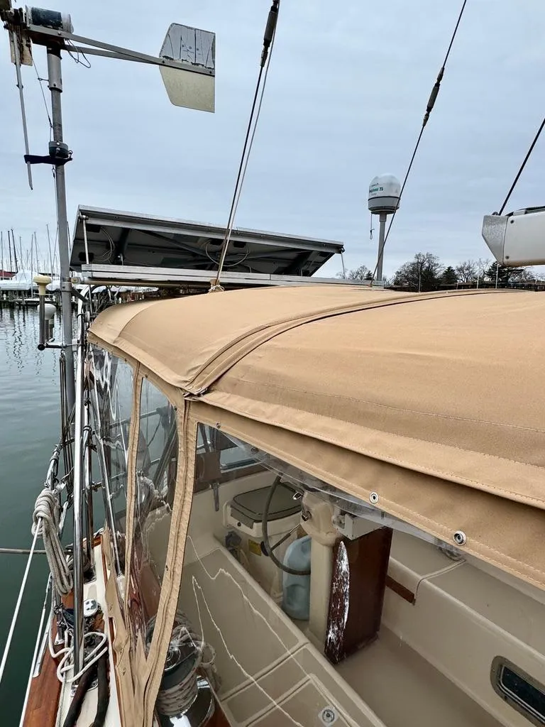 Slide: The Image of Island Packet 40 sailboat, 2000 model, with beige canopy and marina background. - 10