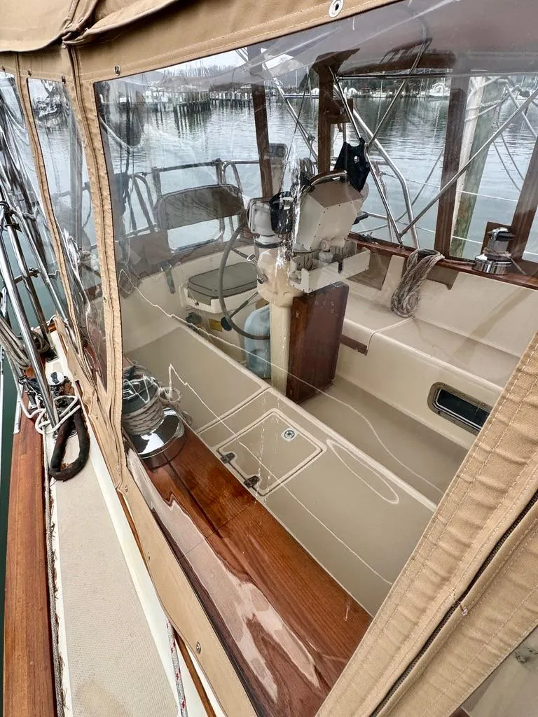 Slide: The Image of 2000 Island Packet 40 sailboat cockpit with clear enclosure and wooden accents. - 11
