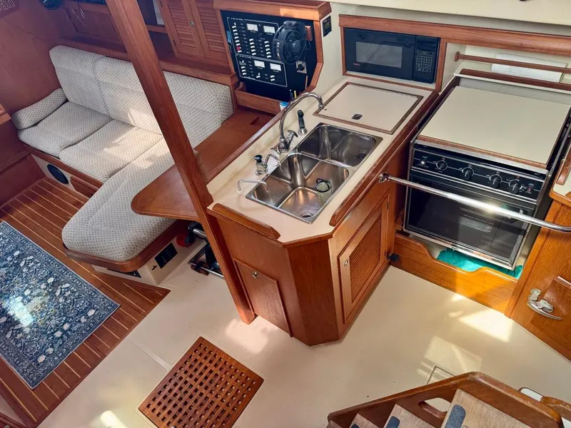 Slide: The Image of Interior of 2000 Island Packet 40 sailboat with kitchen and seating area. - 16