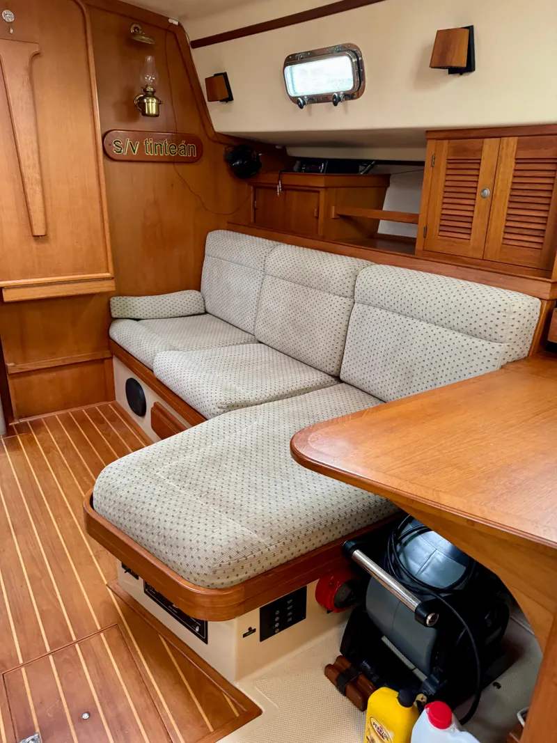 Slide: The Image of Cozy interior of 2000 Island Packet 40 sailboat with cushioned seating and wooden accents. - 17