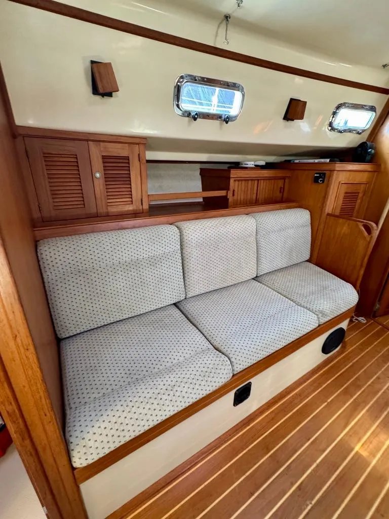 Slide: The Image of Interior of 2000 Island Packet 40 sailboat with cushioned seating and wooden cabinetry. - 18