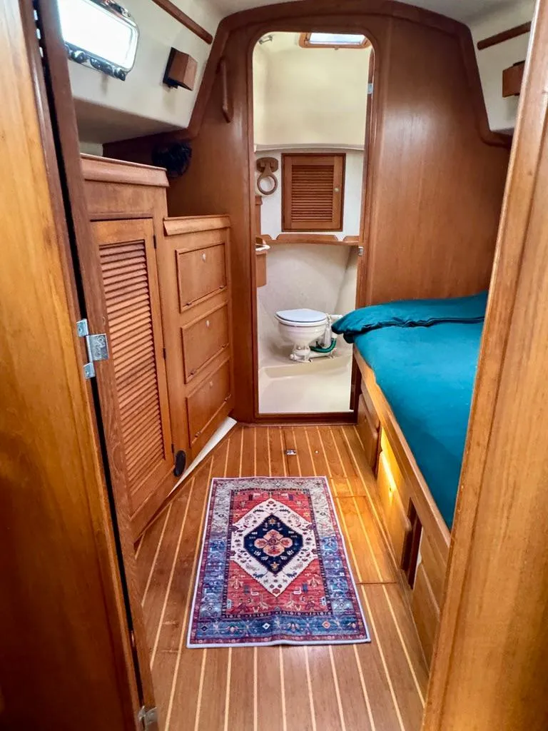 Slide: The Image of Interior of 2000 Island Packet 40 sailboat with wooden cabinetry and cozy sleeping area. - 20