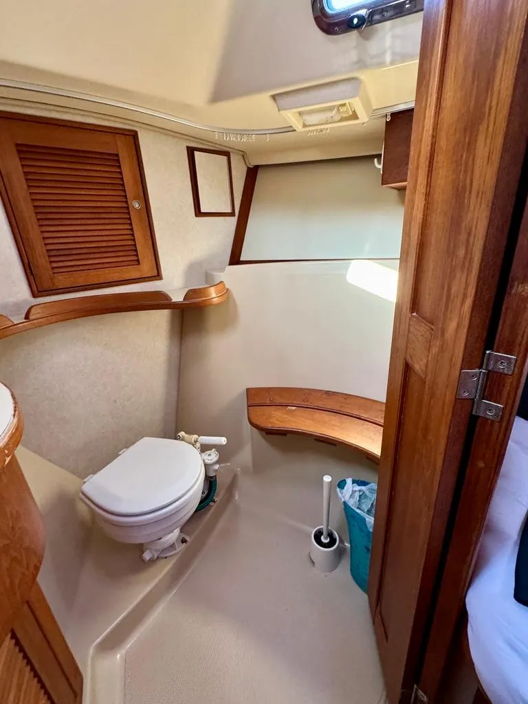 Slide: The Image of Interior of 2000 Island Packet 40 sailboat, featuring a compact bathroom with wooden accents. - 23