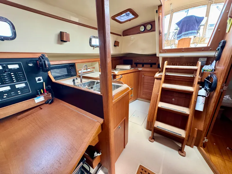 Slide: The Image of Interior of 2000 Island Packet 40 sailboat with wooden cabinetry and stairs. - 31