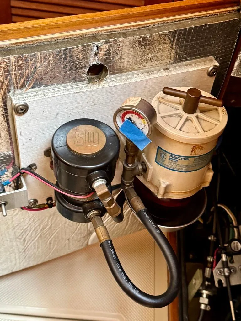 Slide: The Image of Engine compartment of a 2000 Island Packet 40 sailboat, featuring fuel filter and gauge. - 39