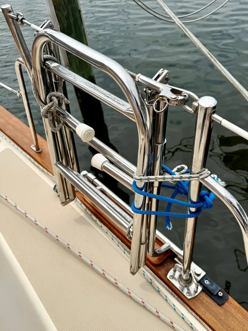 Slide: The Image of Stainless steel ladder on 2000 Island Packet 40 sailboat, docked by the water. - 8