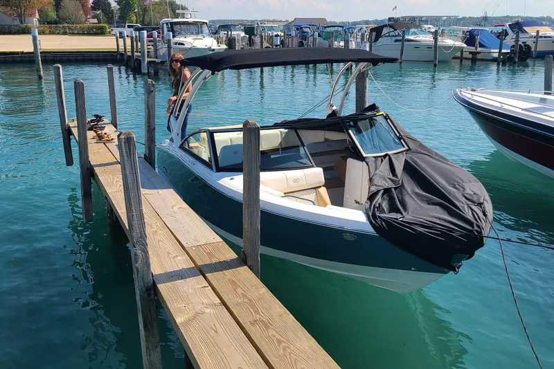 Slide: The Image of 2022 Cobalt CS22 boat docked at a marina with a black canopy. - 3