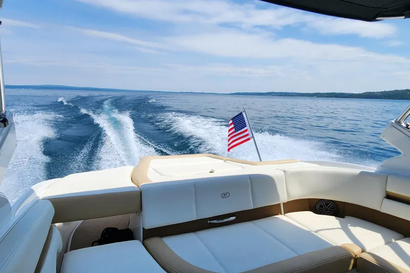 Slide: The Image of 2022 Cobalt CS22 boat cruising on a lake with American flag waving. - 5