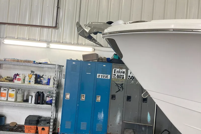 Slide: The Image of 2023 Edgewater 262CC boat in a workshop with lockers and shelves. - 18