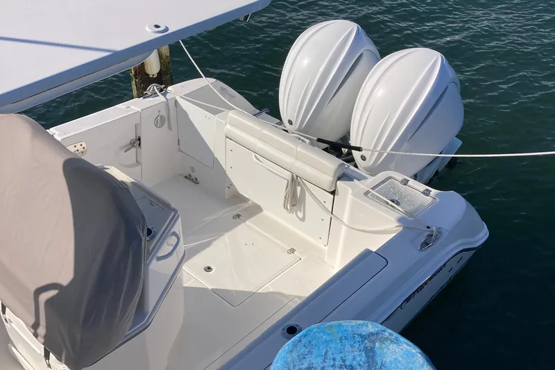 Slide: The Image of 2023 Edgewater 262CC boat with dual outboard motors docked on water. - 21