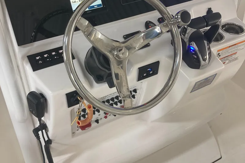 Slide: The Image of 2023 Edgewater 262CC boat dashboard with steering wheel and control panel. - 36