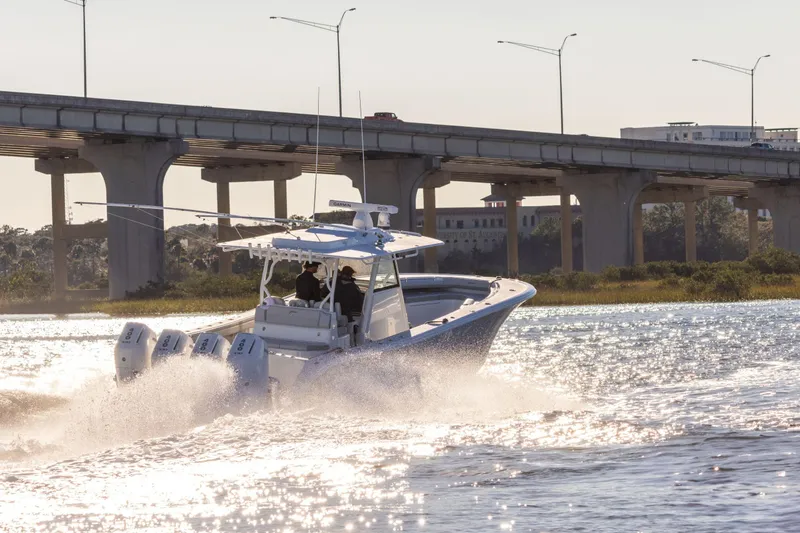 The Image of 2026 Yellowfin 39 Offshore boat cruising on a calm lake with forested shoreline. - 0