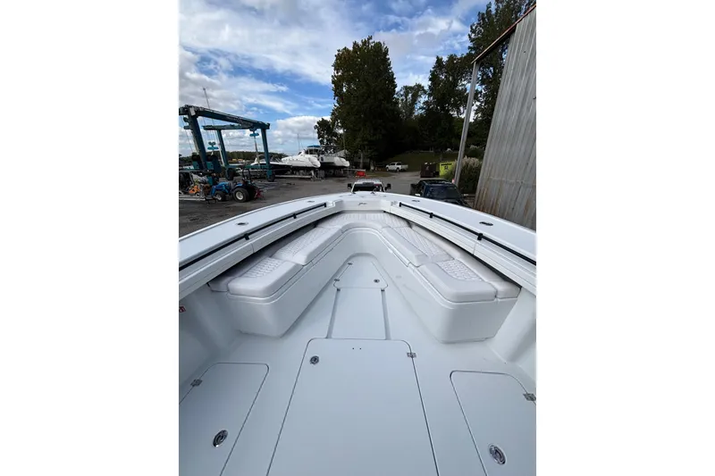 Slide: The Image of 2026 Yellowfin 39 Offshore boat cruising on a calm river near a scenic shoreline. - 13