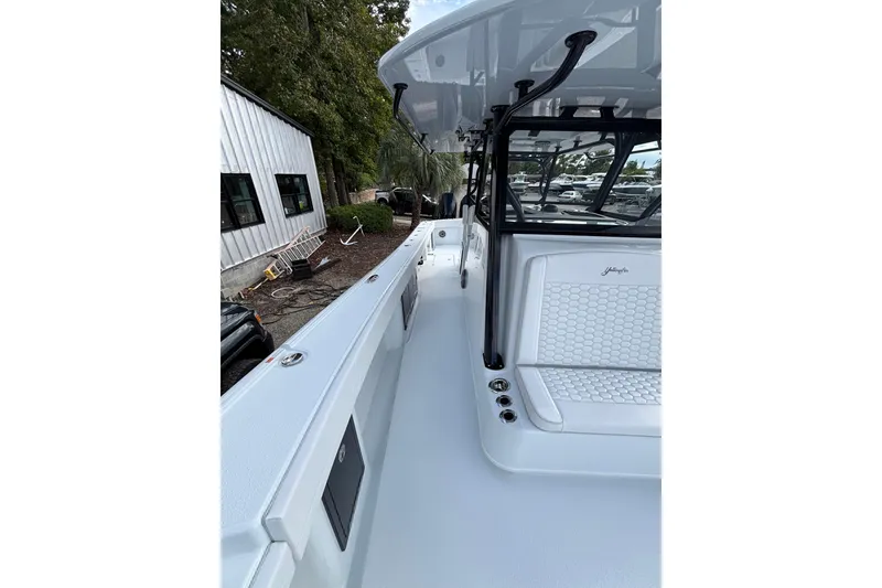 Slide: The Image of 2026 Yellowfin 39 Offshore boat cruising on a calm river near waterfront homes. - 14