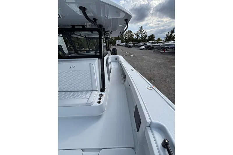 Slide: The Image of 2026 Yellowfin 39 Offshore boat cruising on a calm river near waterfront homes. - 15