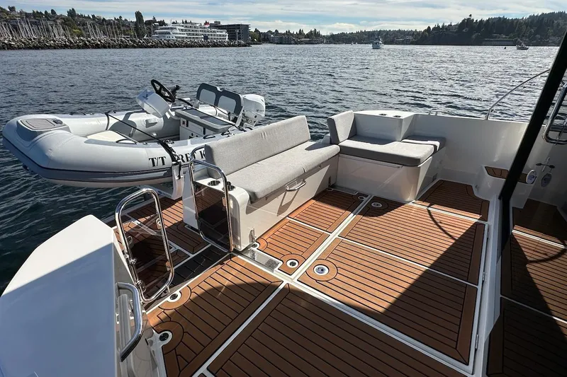 Slide: The Image of 2024 Beneteau Swift Trawler 41 Sedan deck with seating and inflatable boat. - 14